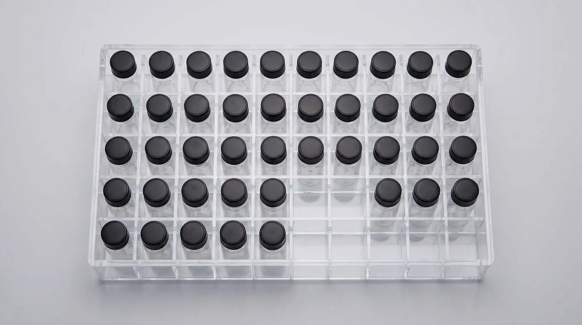 A top-down clear slotted vial box with research vials organized in fixed positions for inventory.
